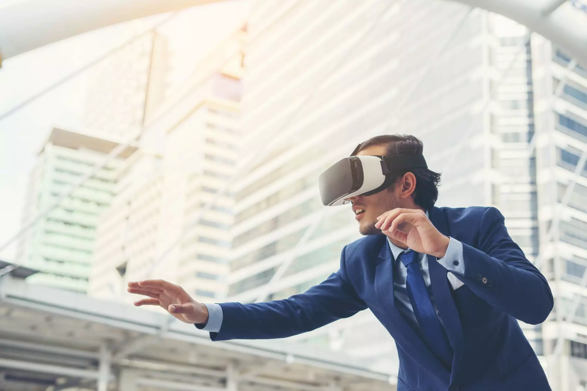 young-businessman-in-black-suit-wearing-virtual-reality-goggles young-businessman-in-black-suit-wearing-virtual-reality-goggles