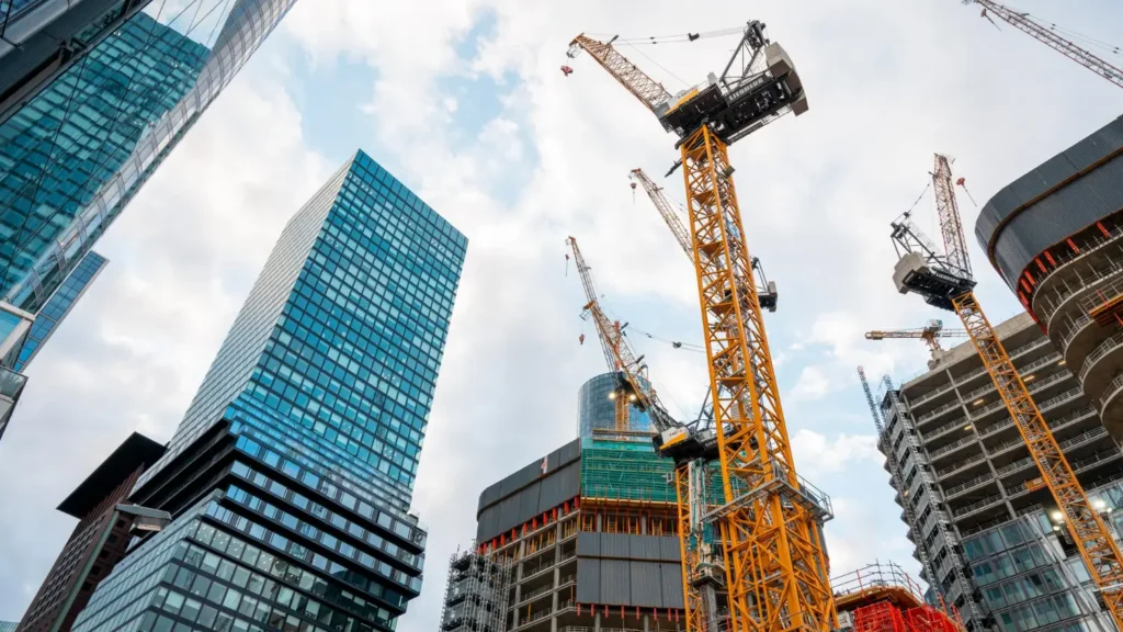High-rise construction site with tower cranes and modern glass buildings