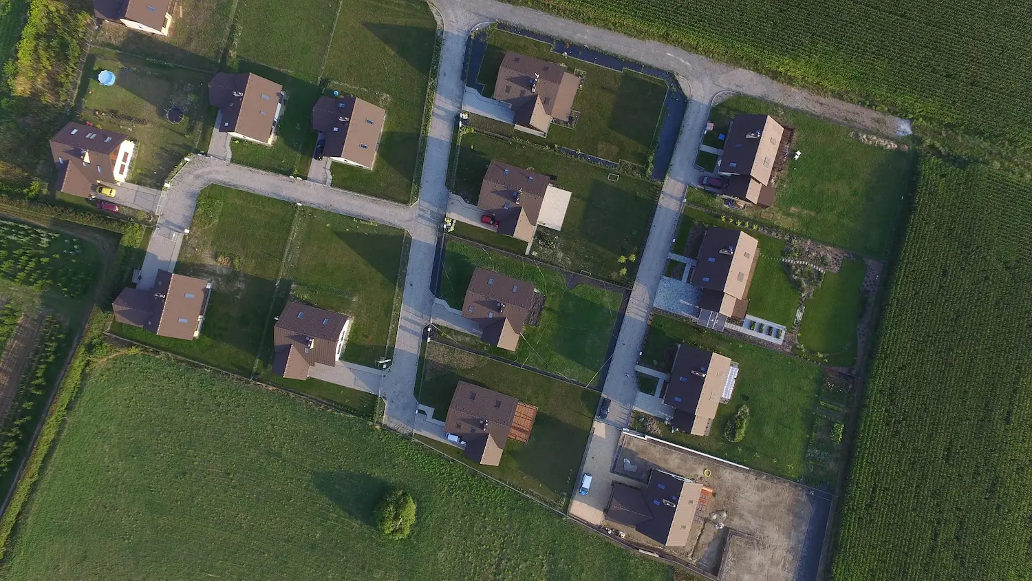 Aerial drone view of residential site layout showing plots, roads, and surrounding landscape for CGI context